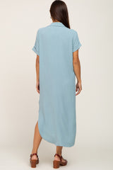back view of woman wearing light blue short sleeve midi shirt dress with side slits and brown sandals