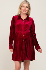 blonde woman wearing a burgundy velvet long sleeve button down maternity dress