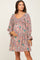 pregnant woman wearing a floral smocked maternity mini dress with long sleeves and gold jewelry
