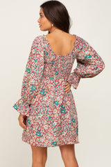 woman wearing a long sleeve floral mini dress with a smocked back and scoop neckline