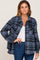 woman wearing a blue and black plaid flannel shirt jacket over a white top and blue jeans