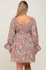 Back view of a woman wearing a red floral smocked mini dress with long bell sleeves and a square neckline