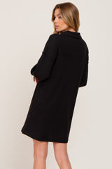 Woman wearing a black long sleeve waffle knit mini dress with a collar seen from the back