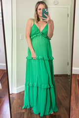 woman in a green tiered maxi dress with ruffle details taking a mirror selfie
