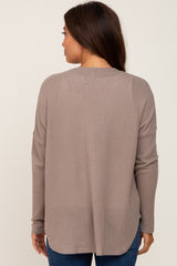 woman wearing a taupe long sleeve maternity top with a relaxed fit and back yoke detail