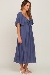 woman wearing a navy blue maxi dress with a tie front and flutter sleeves