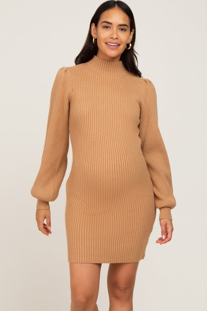 woman wearing a camel ribbed maternity sweater dress with long puff sleeves and a visible baby bump