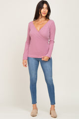 woman wearing a pink long sleeve wrap top paired with light blue skinny jeans and beige slip-on shoes