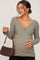 pregnant woman in olive green ribbed v-neck maternity top holding a brown crocodile print handbag