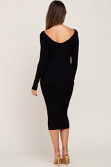 back view of woman wearing long sleeve black ribbed midi dress with v-neckline and tan heels