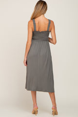 woman wearing a gray smocked maternity dress with spaghetti straps and a midi length, showing a stylish back view