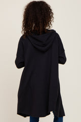 woman wearing a black long hooded cardigan, viewed from the back, with a relaxed fit and curved hem