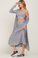 woman wearing a grey three-piece lounge set with a crop top, wrap skirt, and long cardigan