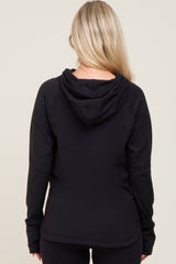 back view of a woman with blonde hair wearing a black long sleeve hooded sweatshirt