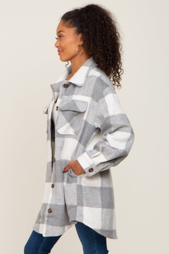 woman wearing a grey and white plaid flannel shacket with front pockets and button details