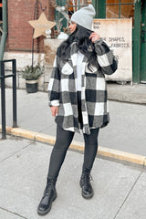woman wearing black and white buffalo plaid shacket with black leggings and combat boots on a city sidewalk