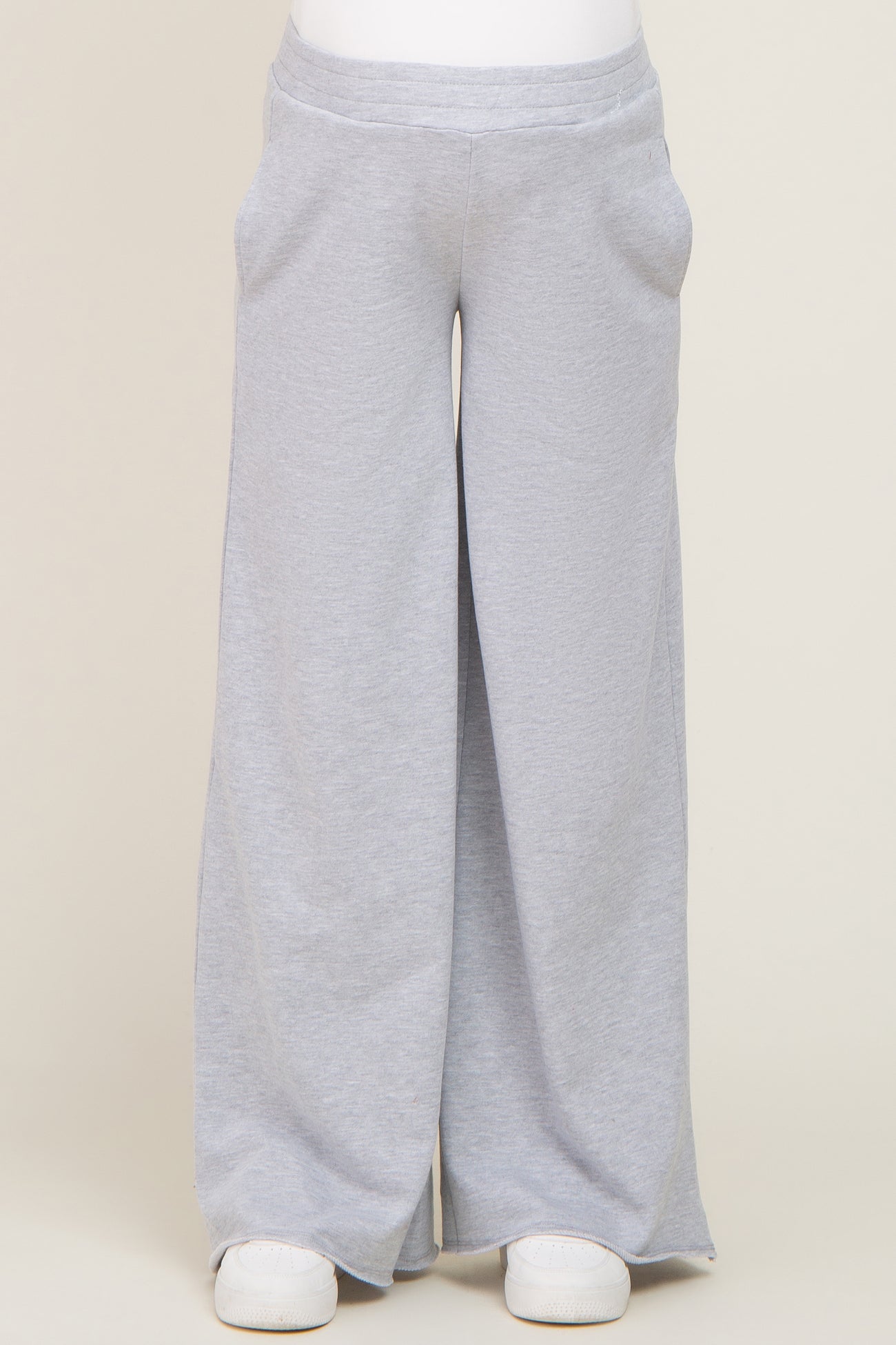 person wearing light grey wide leg sweatpants with side pockets and white sneakers