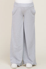 person wearing light grey wide leg sweatpants with side pockets and white sneakers