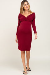 pregnant woman wearing a long sleeve burgundy off the shoulder maternity dress
