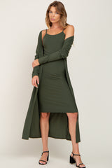 woman wearing a dark green ribbed midi dress with a matching long cardigan and strappy black heels