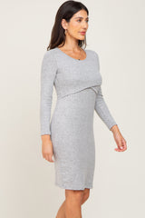 woman wearing a grey long sleeve fitted dress with a twist detail at the waist