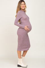Pregnant woman in a mauve long sleeve ribbed maternity midi dress and white ankle boots