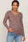 Woman wearing a purple floral long sleeve maternity henley top and light wash jeans
