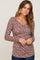 woman wearing a long sleeve floral print henley top in mauve with button details and a v-neckline