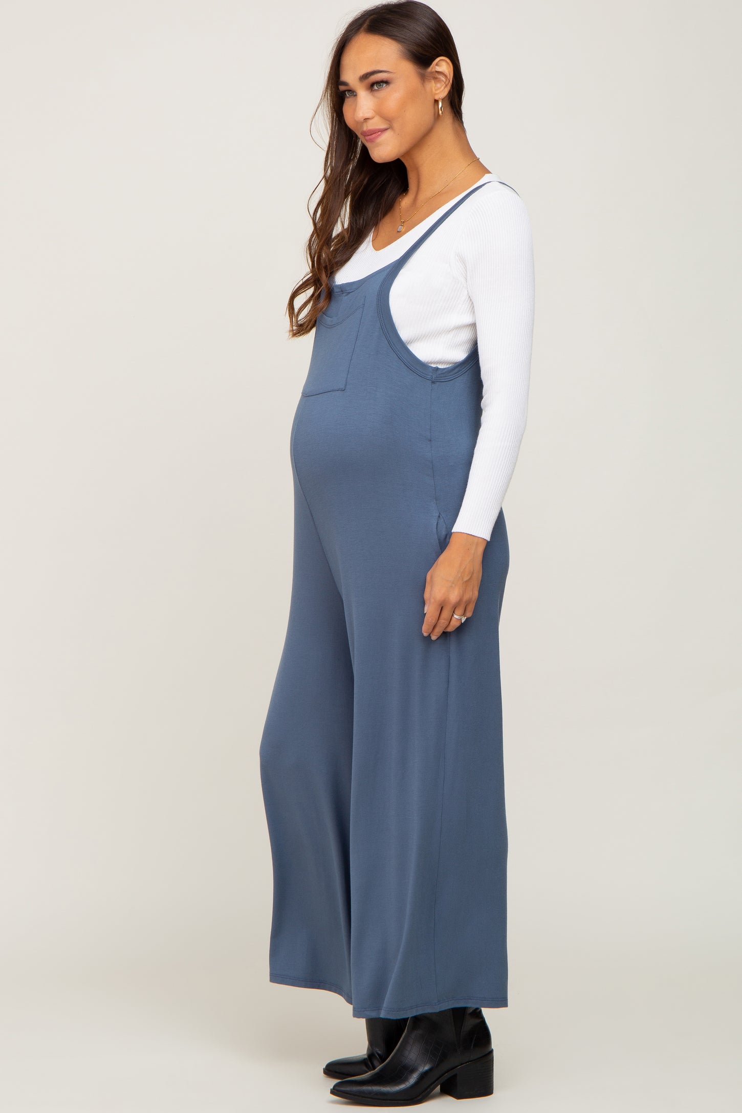 woman wearing a blue maternity jumpsuit with a relaxed fit and a visible baby bump