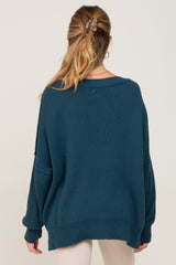 woman wearing a teal oversized maternity sweater with a relaxed fit and dropped shoulders, viewed from the back