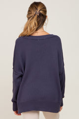 back view of woman wearing oversized navy blue knit sweater with drop shoulders and ribbed hem