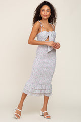 woman wearing a floral smocked midi dress with tie-front cutout and white block heel sandals