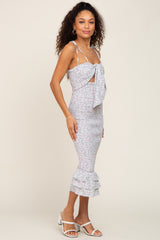 woman wearing a floral smocked midi dress with tie front detail and ruffled hem