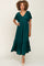 woman with curly hair wearing a dark emerald green v-neck midi dress with flutter sleeves and tiered skirt