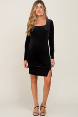 woman wearing a black long sleeve maternity dress with a square neckline and side slit