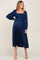 woman wearing a navy blue maternity dress with a smocked bodice and long puff sleeves, showcasing her baby bump