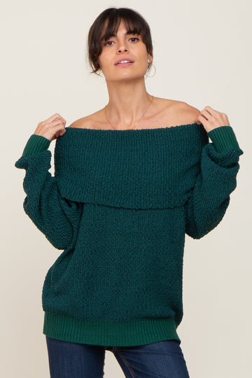 woman wearing a dark green off-the-shoulder sweater with a textured design and relaxed fit
