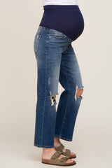 Pregnant woman wearing distressed maternity jeans with a navy blue belly band and olive green sandals