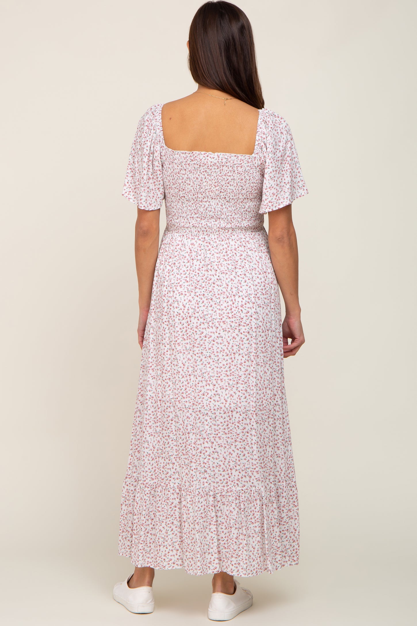 back view of woman wearing white floral smocked maxi dress with short puff sleeves and square neckline