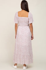 back view of woman wearing white floral smocked maxi dress with short puff sleeves and square neckline
