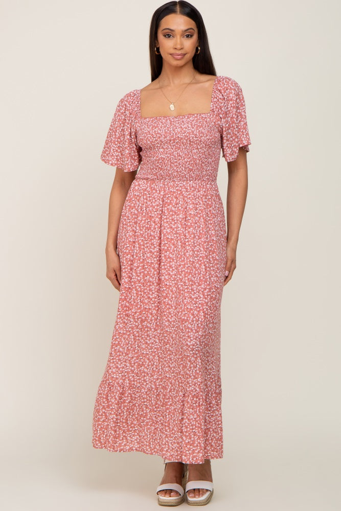 woman wearing a pink floral maxi dress with short puff sleeves and a smocked bodice