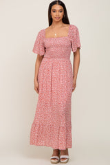 woman wearing a pink floral maxi dress with short puff sleeves and a smocked bodice