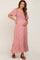 woman wearing a pink floral maternity maxi dress and holding her baby bump