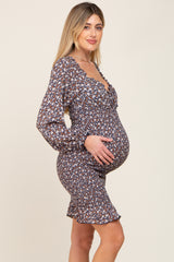 Pregnant woman in a long-sleeved floral maternity dress with smocked bodice and ruffle hem