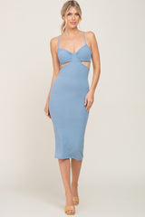 woman wearing a light blue ribbed midi dress with side cutouts and spaghetti straps