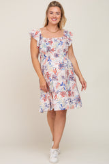 woman wearing a floral smocked maternity dress with ruffle sleeves and white sneakers