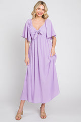 woman wearing a lavender maxi dress with flutter sleeves and a front tie detail