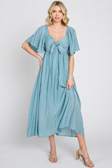 woman wearing a light blue maxi dress with short flutter sleeves and a front tie detail