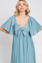 woman wearing a light blue maxi dress with flutter sleeves and a tied front detail