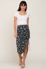 woman wearing a white short sleeve crop top and a floral print midi skirt with a side slit and drawstring detail
